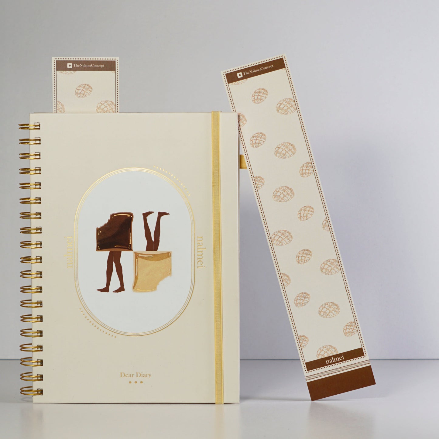 A brown and beige large bookmark with melonpan bread illustration outlined leaning on a quotes journal| Nalmei