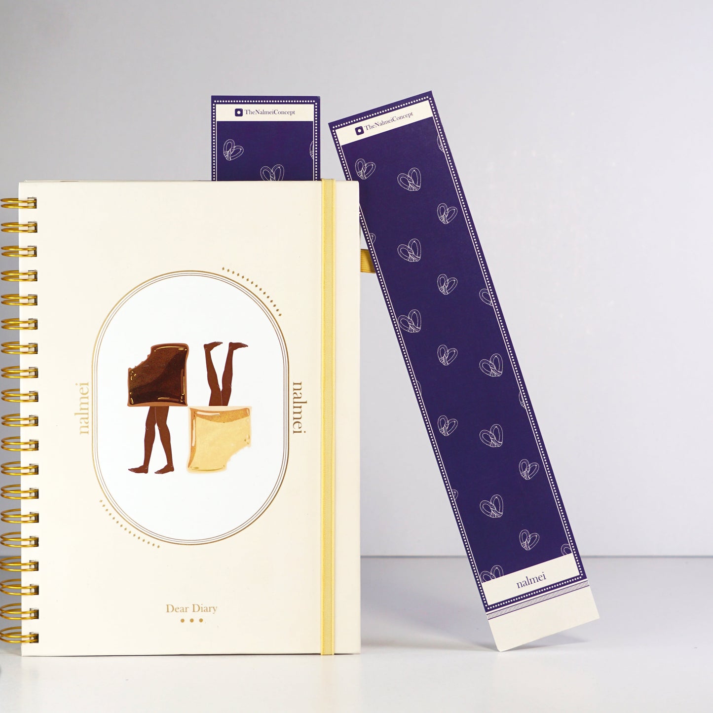 A purple and beige large bookmark with pretzel illustrations leaning on a quotes journal | Nalmei
