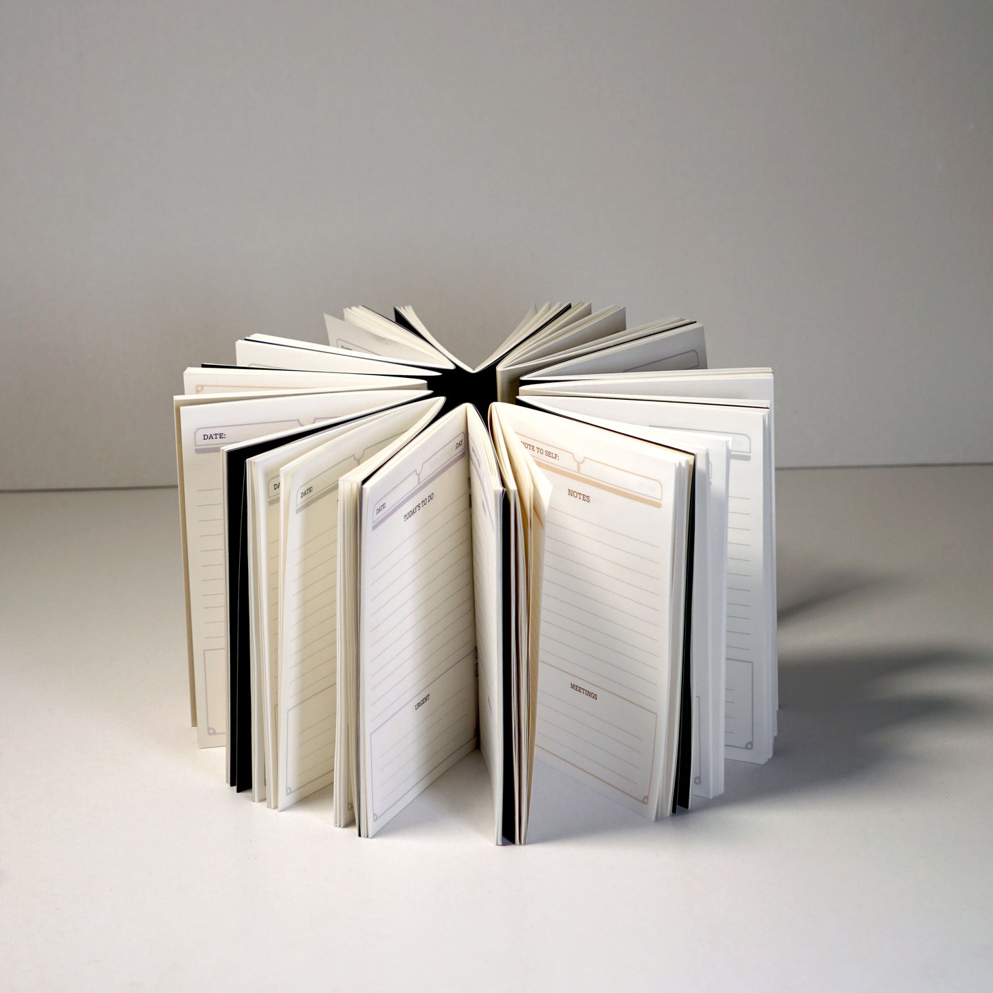 A set of 12 pocket notebooks with Black, Beige and Purple Croissants and Pretzels illustrations | Nalmei